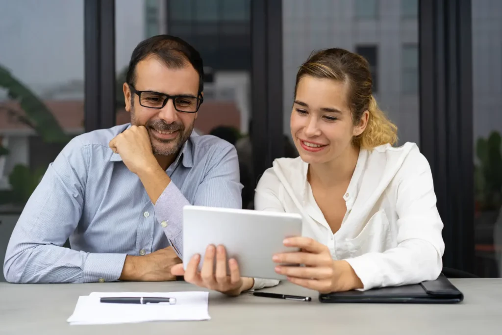 Two business professionals reviewing documents together during an office meeting