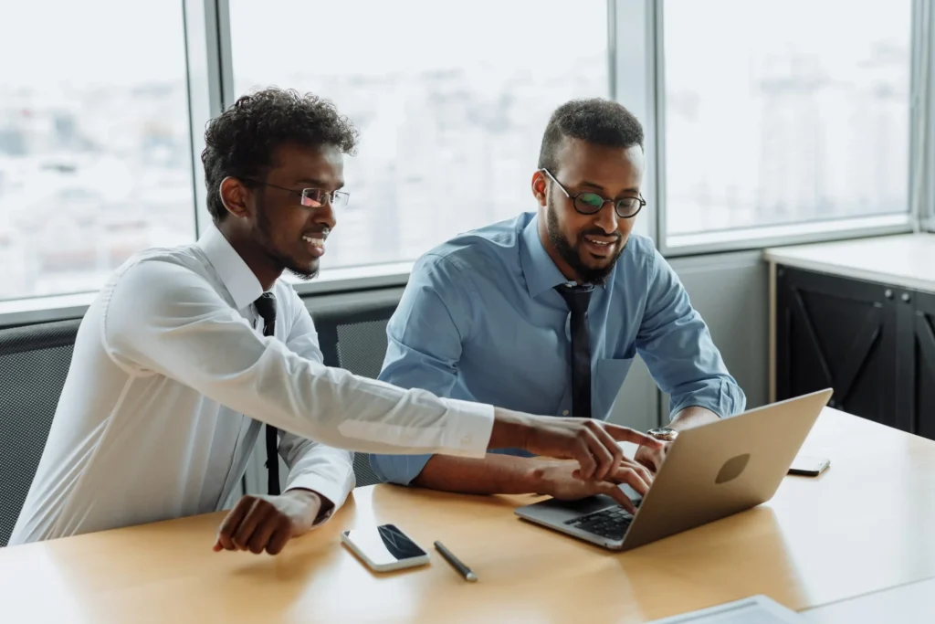 Two coworkers collaborating on a laptop during a business meeting